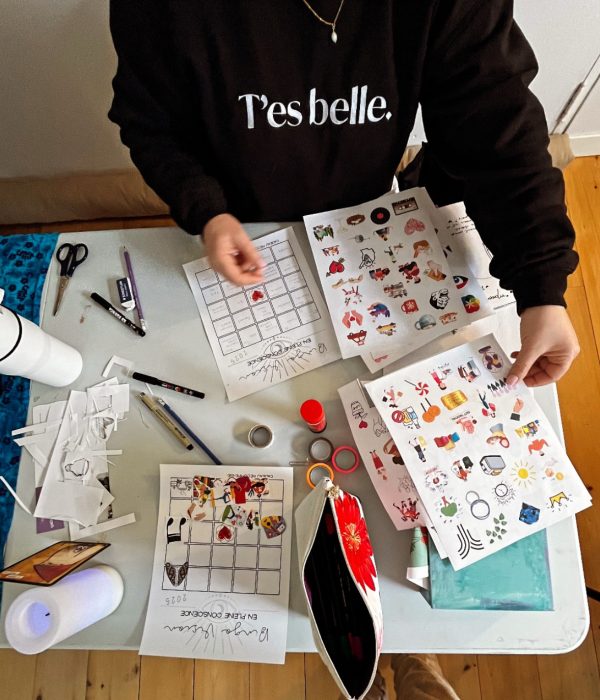 Atelier de collage intuitif Personne participant à un atelier de collage intuitif, découpant et assemblant des images sur une table avec outils créatifs.